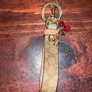 Coach Signature Cherry Loop Key Ring in gold and khaki with red cherry accents